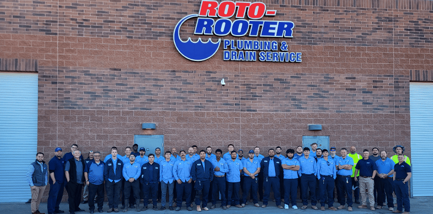 Phoenix Roto-Rooter technicians standing in a line outside building