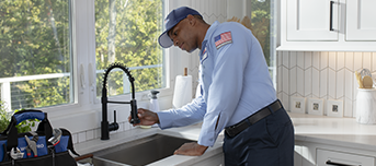 Roto-Rooter technician inspecting kitchen sink