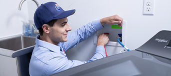 Roto-Rooter plumber diligently repairing damaged washing machine