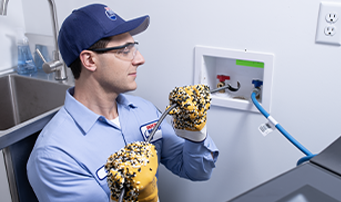 Plumber carefully inspects washing machine