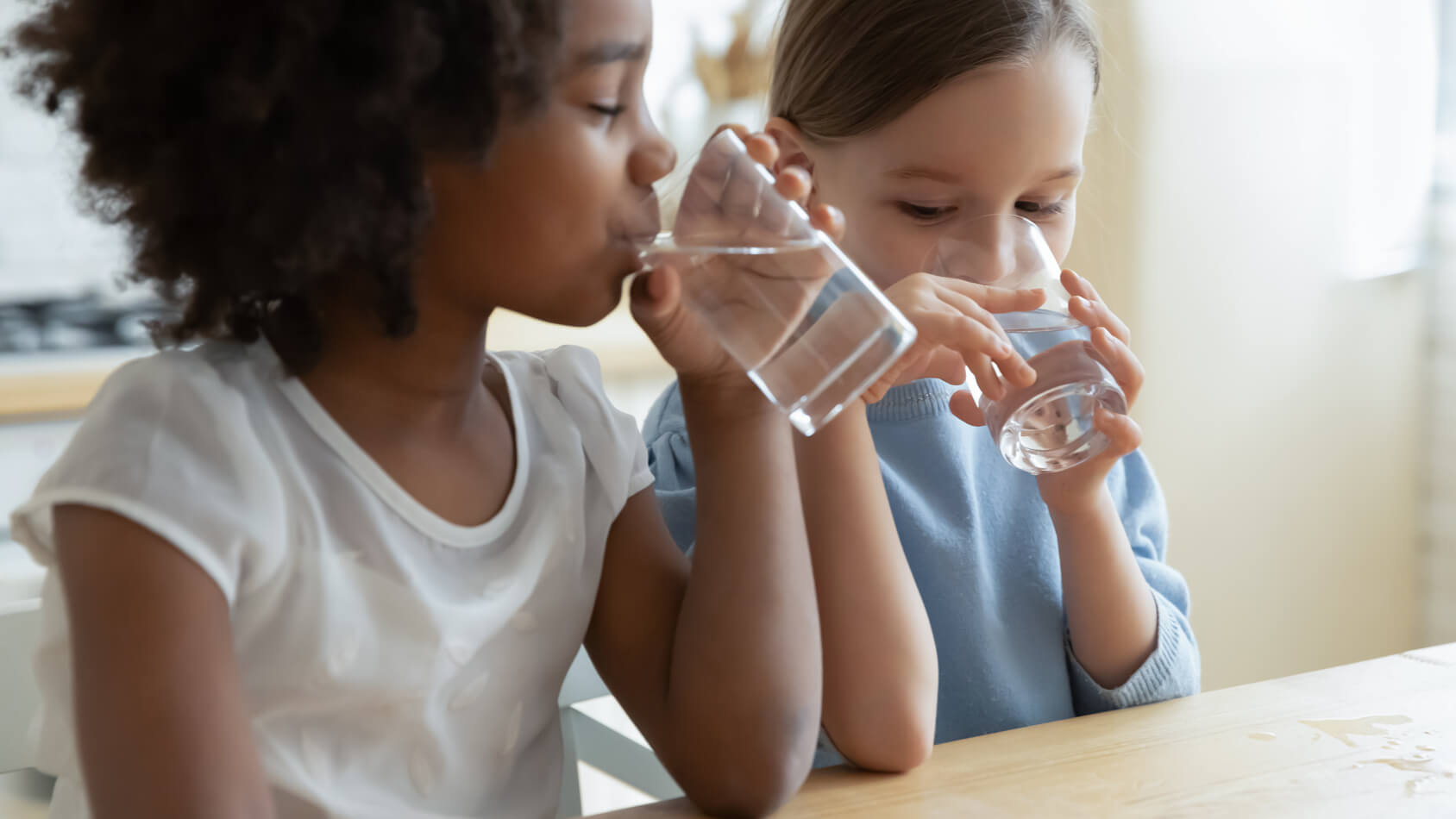 Two children drinking water